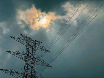 Low angle view of silhouette electricity pylon against sky