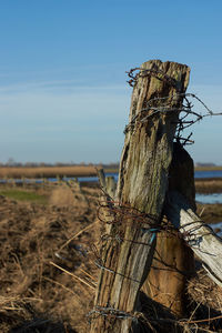 Wooden fence on field against sky