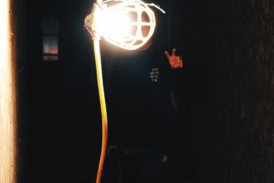 Low angle view of illuminated hands against sky at night