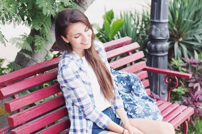 Smiling young woman sitting on bench