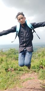 Young man standing on land against sky