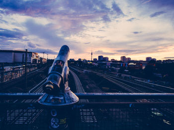 Man in city against sky during sunset