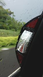 Close-up of wet car against sky