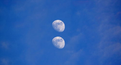 Low angle view of moon in blue sky