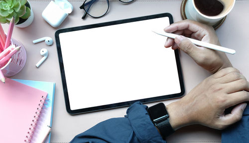 Midsection of person using mobile phone on table