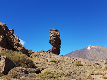 Rock formations in desert against blue sky