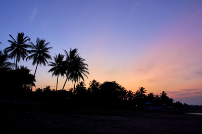 Silhouette palm trees against sky during sunset