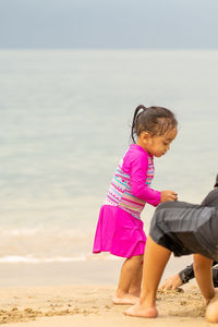 Side view of girl playing at beach