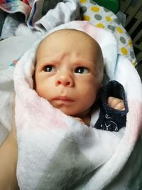 Portrait of cute baby girl lying on bed