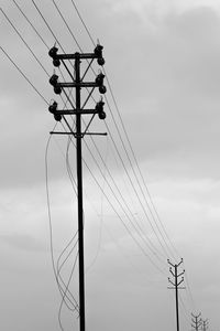 Low angle view of electricity pylon against sky