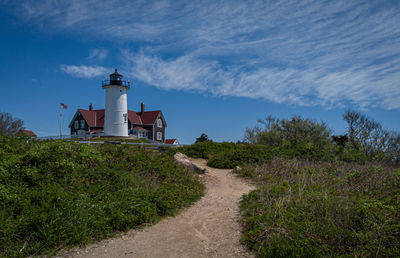 Lighthouse amidst buildings against sky