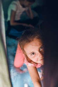 Two girls sisters spending family time in a tent on camping. children using tablet playing games