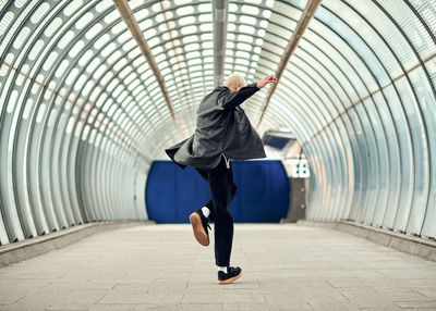 Full length of man and woman standing on footpath in tunnel