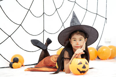 Full length portrait of boy holding pumpkin