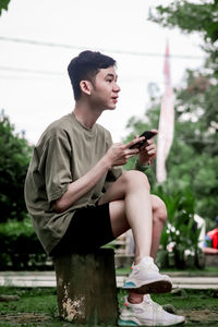 Portrait of young man sitting on field