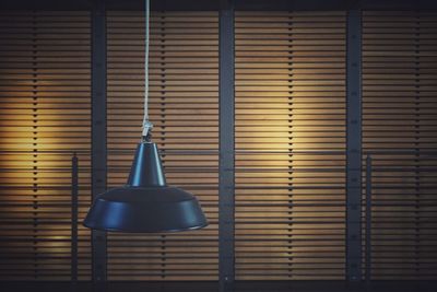 Close-up of electric lamp hanging in dark