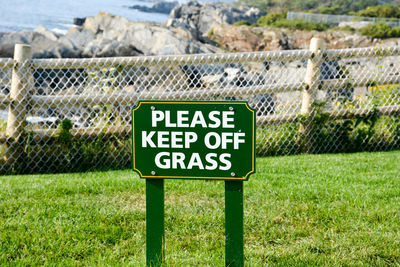 Close-up of information sign on grass