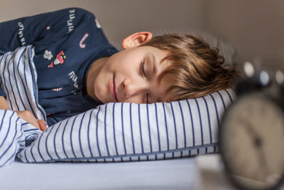 Portrait of boy sleeping on bed at home