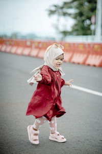 Rear view of woman walking on road