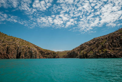 Scenic view of sea and mountains against sky