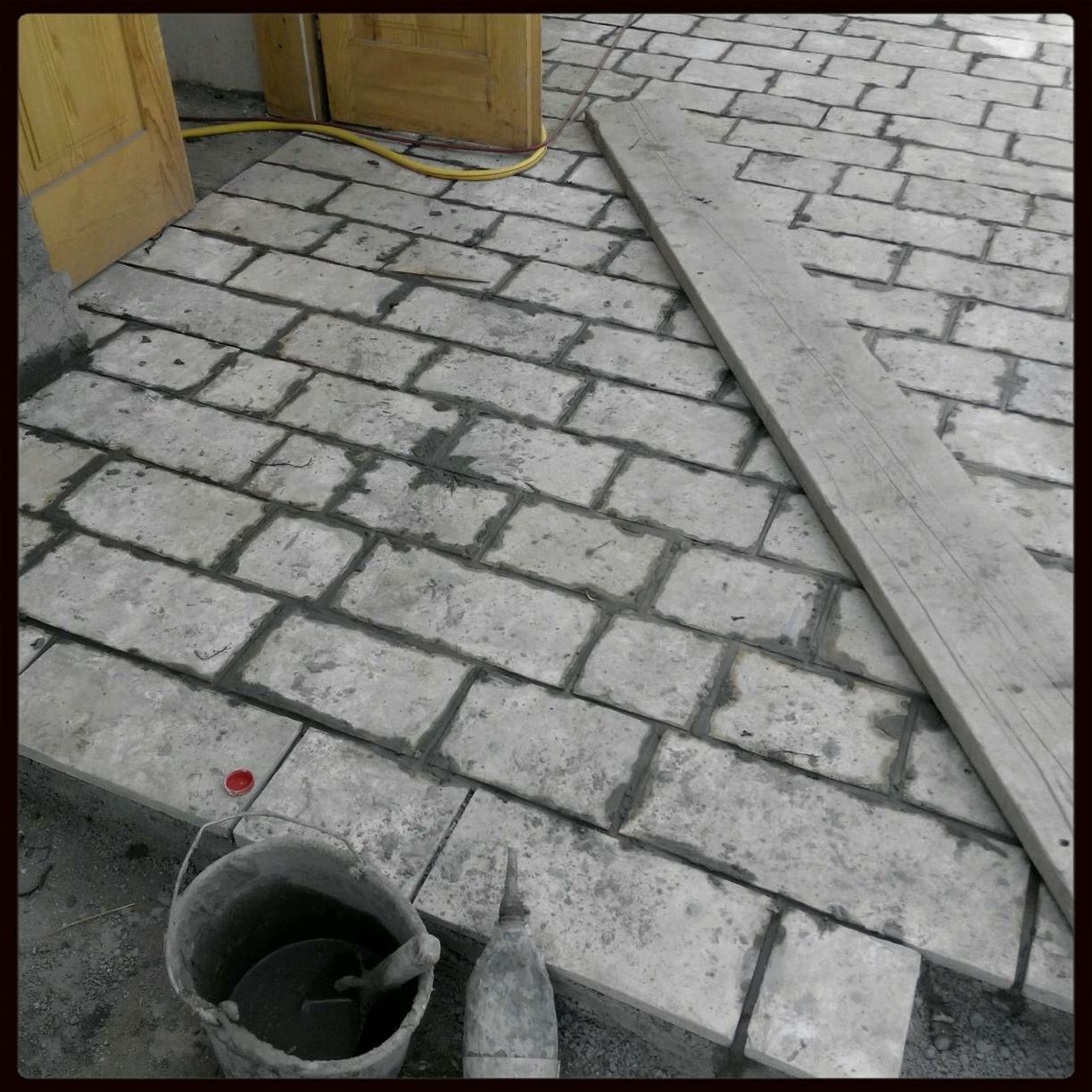 transfer print, high angle view, cobblestone, auto post production filter, paving stone, street, sidewalk, pavement, day, footpath, outdoors, tiled floor, sunlight, empty, red, shoe, elevated view, no people, absence, low section