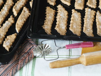 The chopped raw biscuits are placed on black baking trays in the oven. blurred foreground.