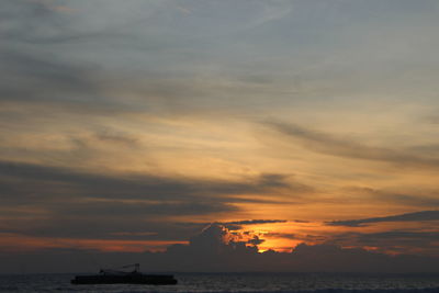 Scenic view of sea against dramatic sky during sunset