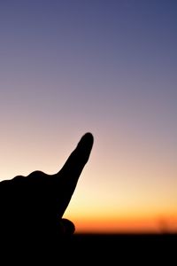 Silhouette person against clear sky during sunset