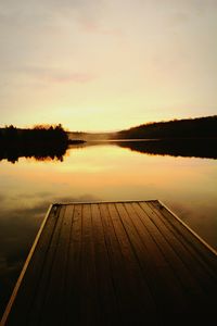 Pier on lake at sunset