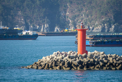 Lighthouse by sea against rocks