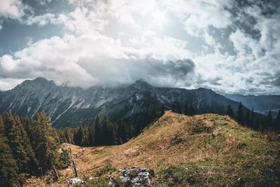 Scenic view of mountains against cloudy sky