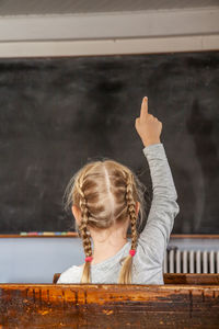 Portrait of girl with arms raised in background