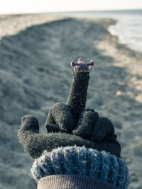Close-up of hand holding crystal ball on beach