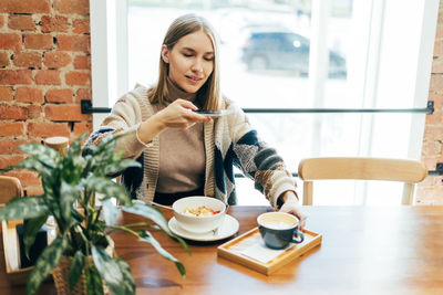 Young woman sitting on table at cafe