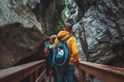 Rear view of people on rock by mountain