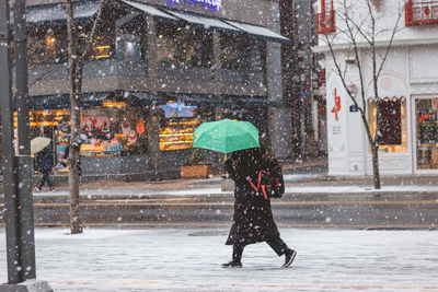 Full length of wet walking on street during winter