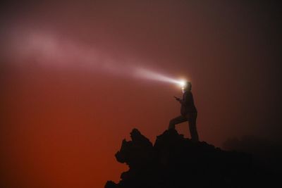 Silhouette woman standing on cliff against clear sky