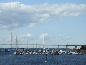 Sailboats on bay bridge against sky