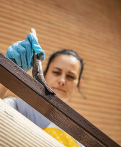 Low angle view of woman painting on railing