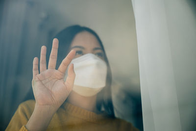 Cropped image of woman looking through window