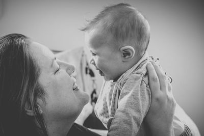 Side view of mother playing with daughter at home