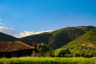 House on field against clear blue sky