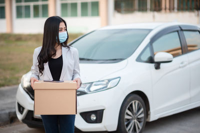 Woman holding smart phone in car