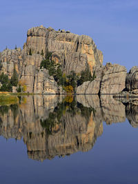 Reflection of rock formation in lake against sky