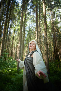 Portrait of woman standing in forest