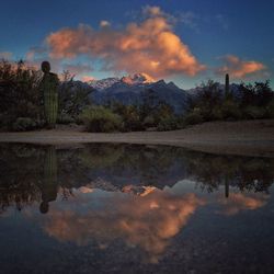 Scenic view of calm lake against cloudy sky