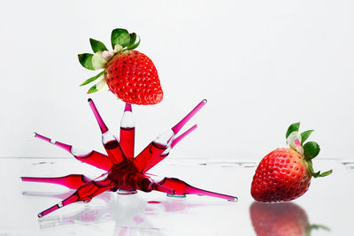 Directly above shot of strawberries on table against white background