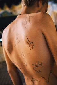Rear view of shirtless woman with tattoo