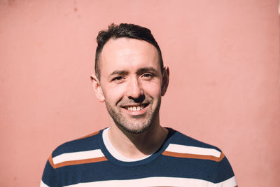 Portrait of smiling man standing against wall