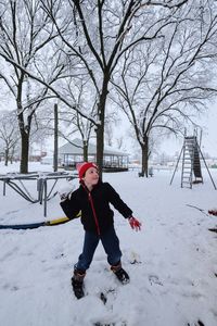 Full length of boy playing in snow